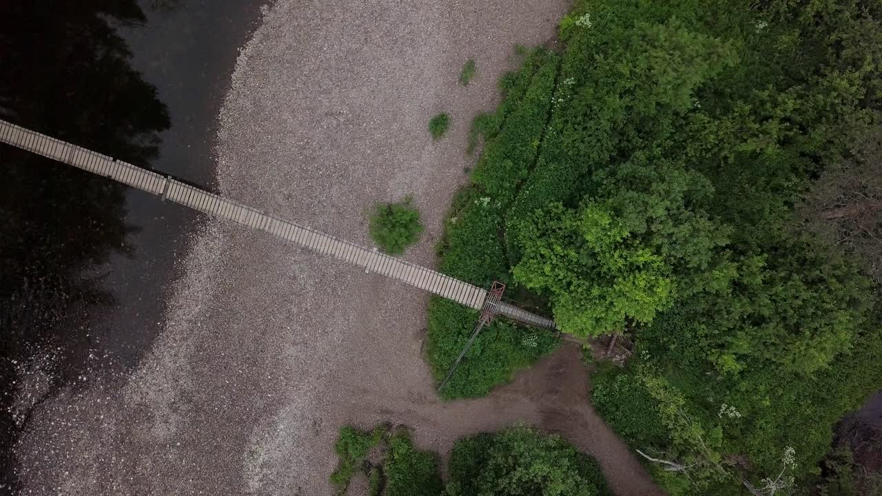 vista aérea de un puente de madera sobre un río en el bosque