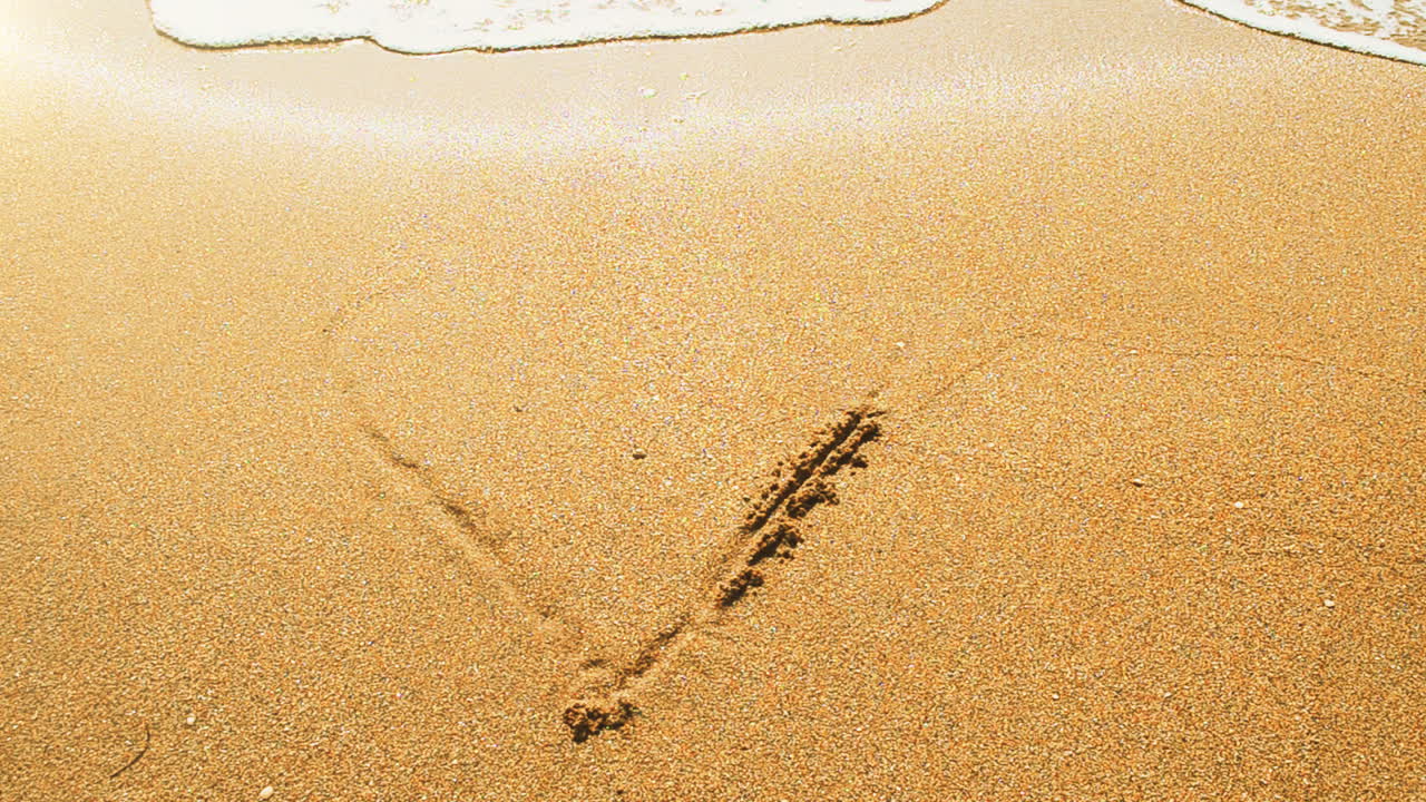 The drawing of heart on sand. Shooting on the beach