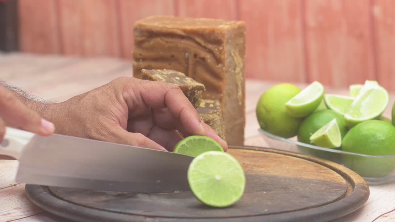 Close-up rustic, authentic food preparation process. Handmade ingredients for a refreshing and traditional South American beverage with lime and Panela
