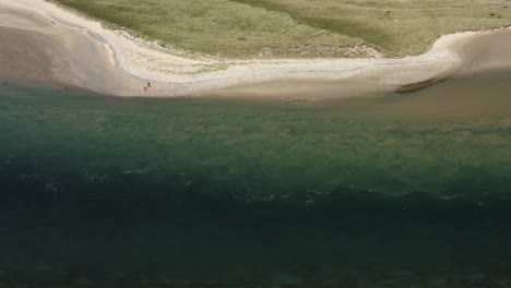 la gente se reúne en las dunas de arena de tramore para ver el flujo de marea turbulento
