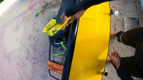 person removes surfboard from his motorbike and going