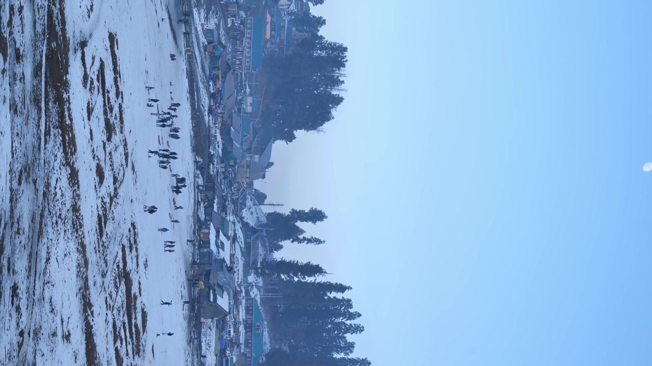 Vista aerea di Gulmarg in inverno con neve e luna nel Jammu e Kashmir, India. Ripresa verticale inclinata 4k.