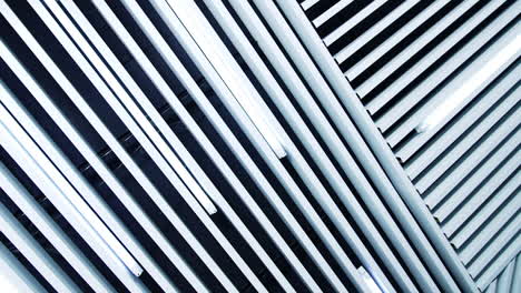 long lamps of daylight on the ceiling. white planks parallel to the illumination equipment.