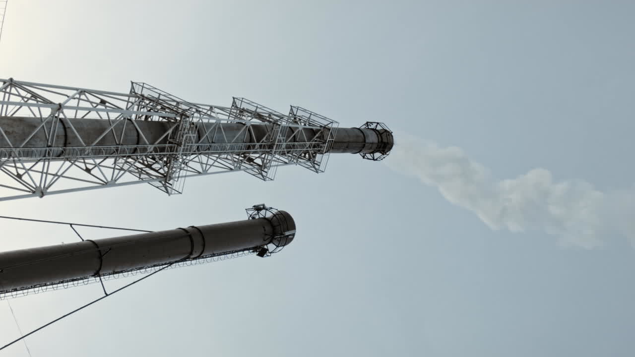 땅에서 연기가 나는 푸른 하늘 위로 산업 공장 파이프