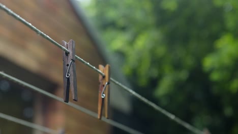 clavijas de madera colgadas en la cuerda de la ropa después de la lluvia