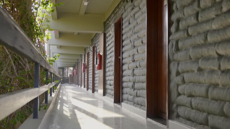 Inquadratura statica di un lungo corridoio davanti alle porte degli appartamenti in un edificio.