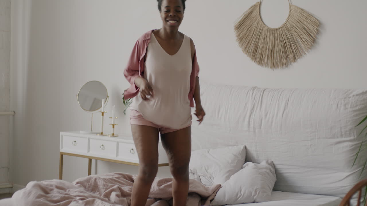 mujer bailando en una cama