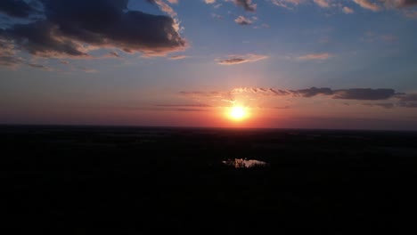 Timelapse-of-clouds-moving-in-colorful-sky-over-rural-landscape-at-dusk