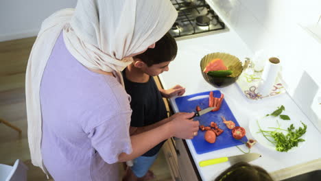 top view of mother with hiyab and her son in the kitchen.