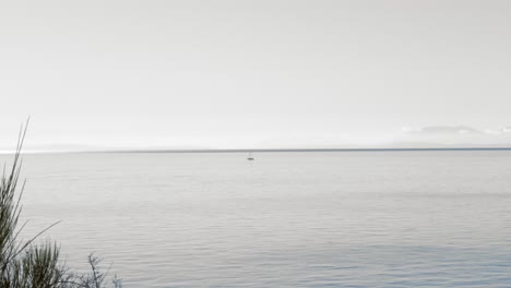 an idyllic scene of a lone boat in the middle of howe sound in british columbia, canada