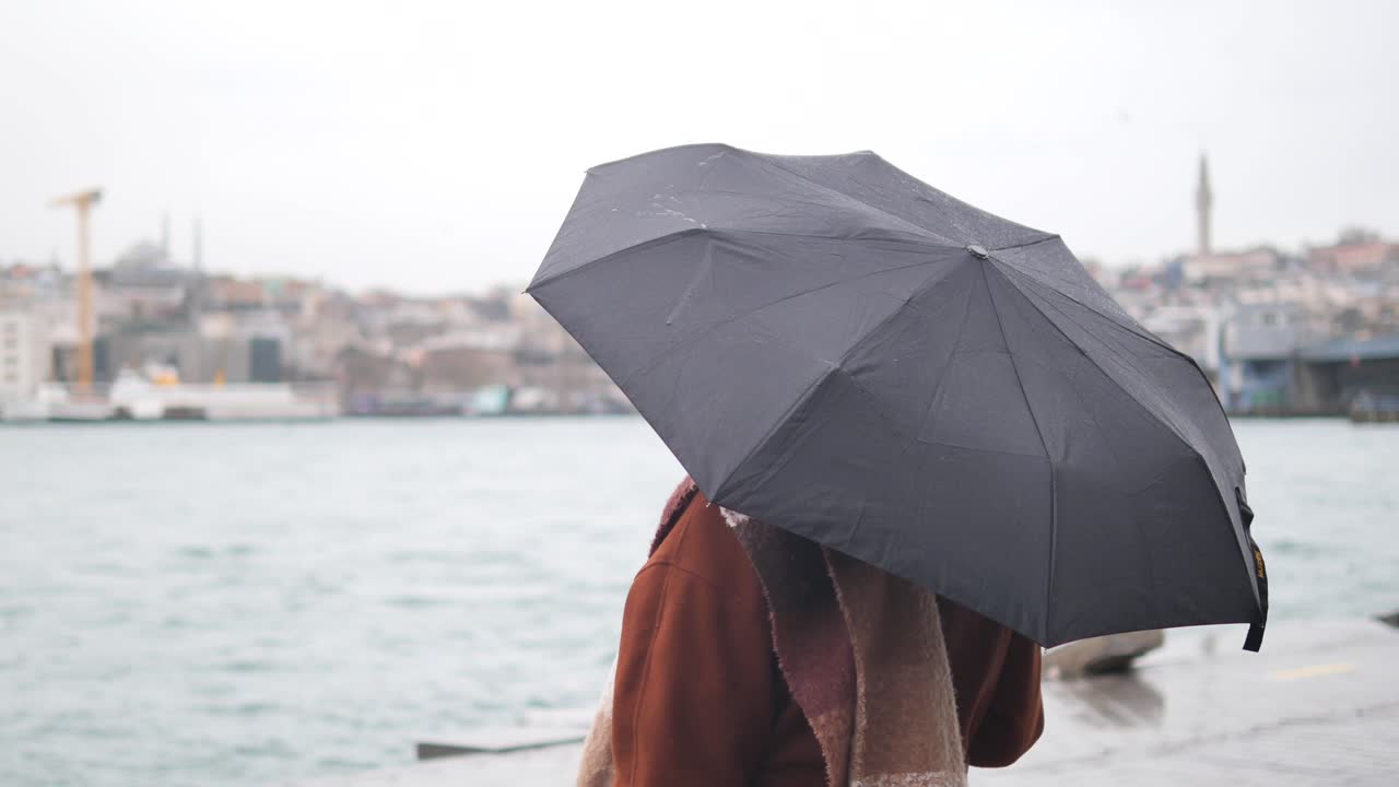 비가 오는 이스탄불에서 우산을 들고 있는 여자