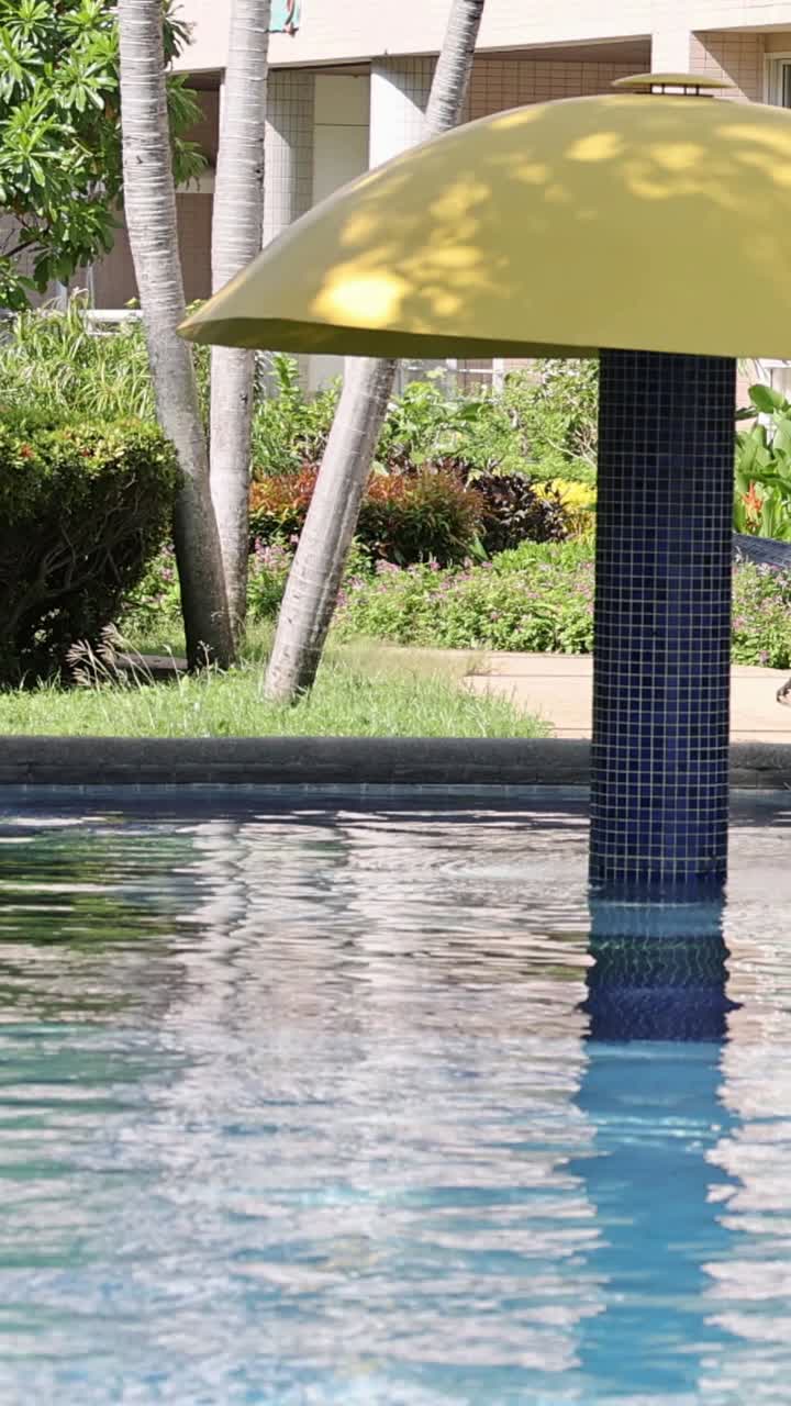 paraguas junto a una piscina con patrones de agua cambiantes