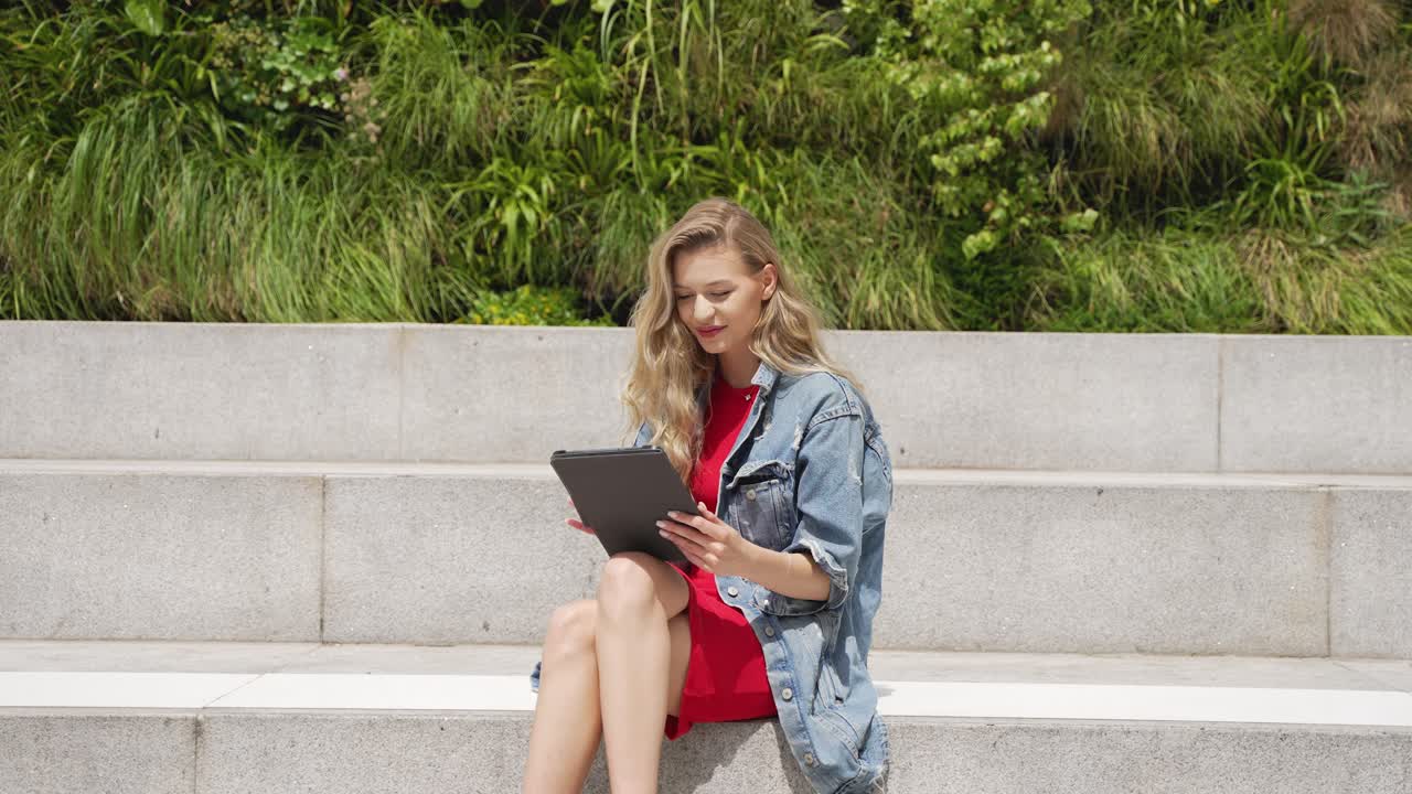 mujer usando tableta en los escalones