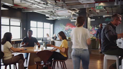 millennial creative business colleagues working and socialising in their office cafe area