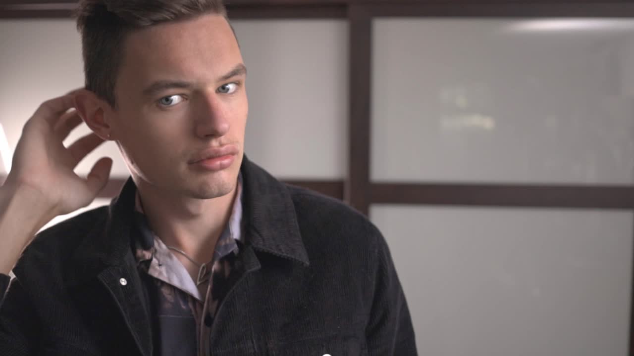 Closeup Image Of A Guy With Gray Eyes Stroking His Hair With His Hands