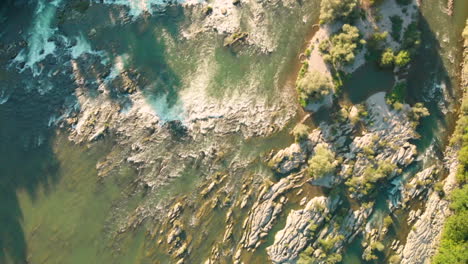 Birdseye-view-of-a-natural-river-with-a-tiny-island-with-trees,-Oldrhine,-Germany