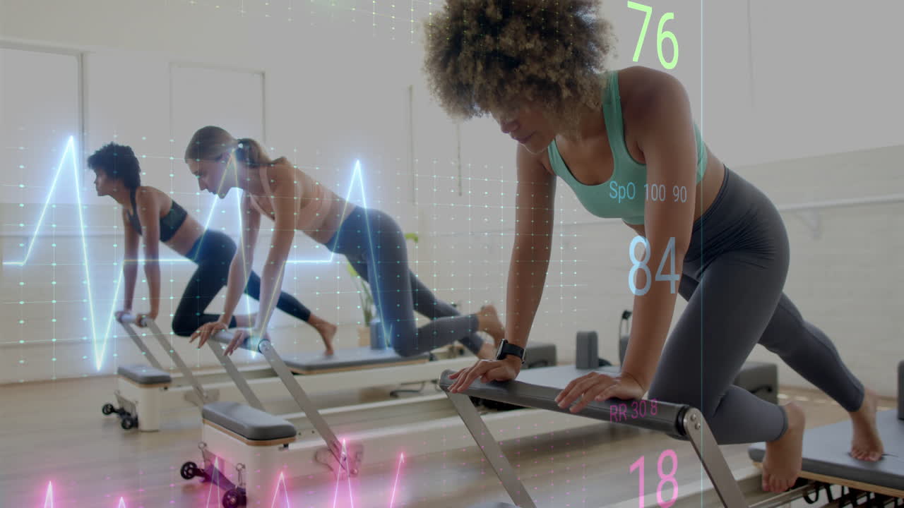 Women exercising on reformer machines with heart rate data overlay animation