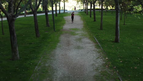 woman jogging towards the camera in enrique tierno galván park in madrid