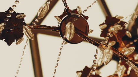 metal luster decorated with glass stones hangs on ceiling