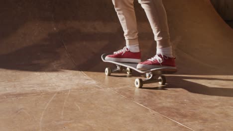 Video-of-legs-of-caucasian-female-skateboarder-training-in-skate-park