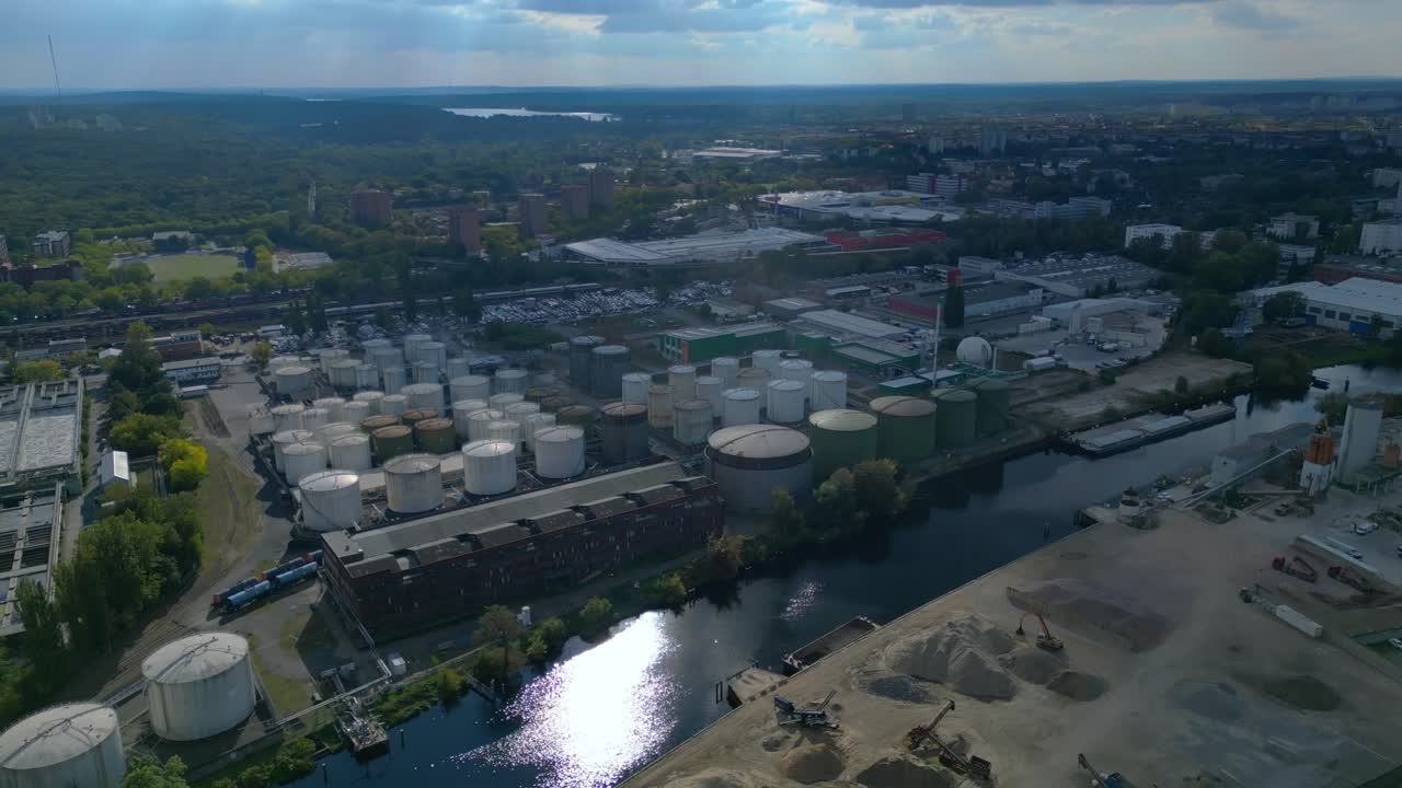 Berlin biogas plant with storage tanks by Spree river, producing renewable energy. Lovely aerial view flight wide orbit overview drone