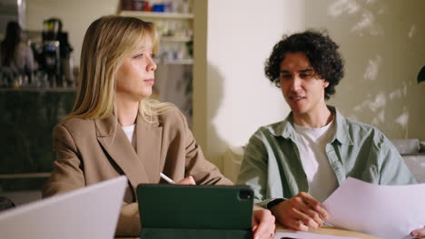 dos jóvenes profesionales teniendo una reunión de negocios en una cafetería