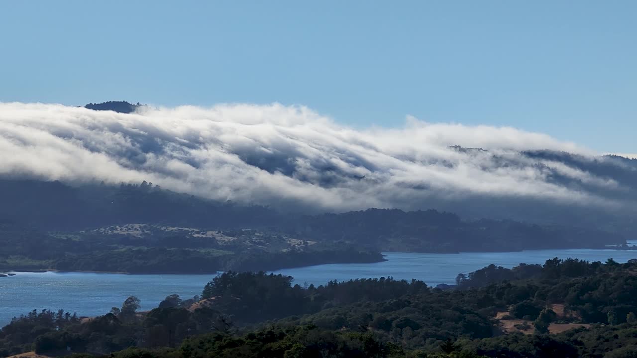 olas de nubes que fluyen sobre los picos del embalse de crystal springs en el condado de san mateo, california, cerca de la i-280