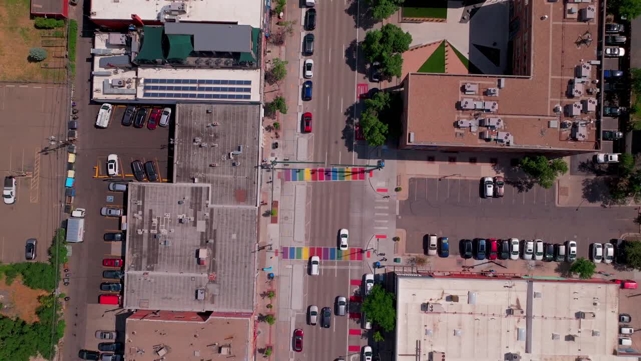 Rainbow cross walk Downtown Denver Colorado South Broadway street aerial drone view landscape businesses restaurants traffic cars pedestrian traffic bike crossing road summer sunny afternoon upwards