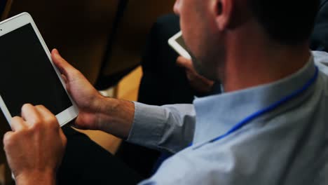 Business-executives-participating-in-a-business-meeting-using-digital-tablet