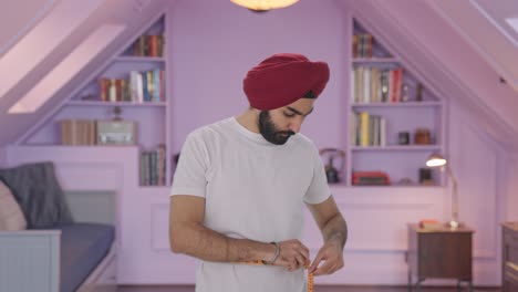 sad sikh indian man measuring waist using inch tape