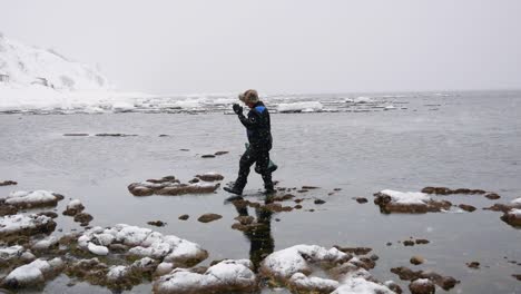 fisherman with a fishnet walks along the beach in winter and collects delicacies