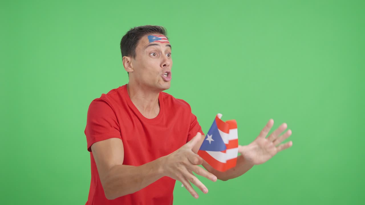 Man cheering for Puerto Rico waving a national flag looking away