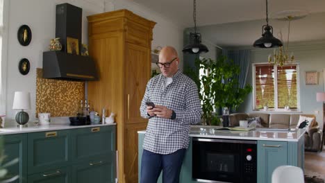 man using phone in a modern kitchen