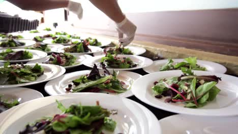 Chef's-hands-putting-chopped-almonds-and-blueberries-at-a-salad-banquet