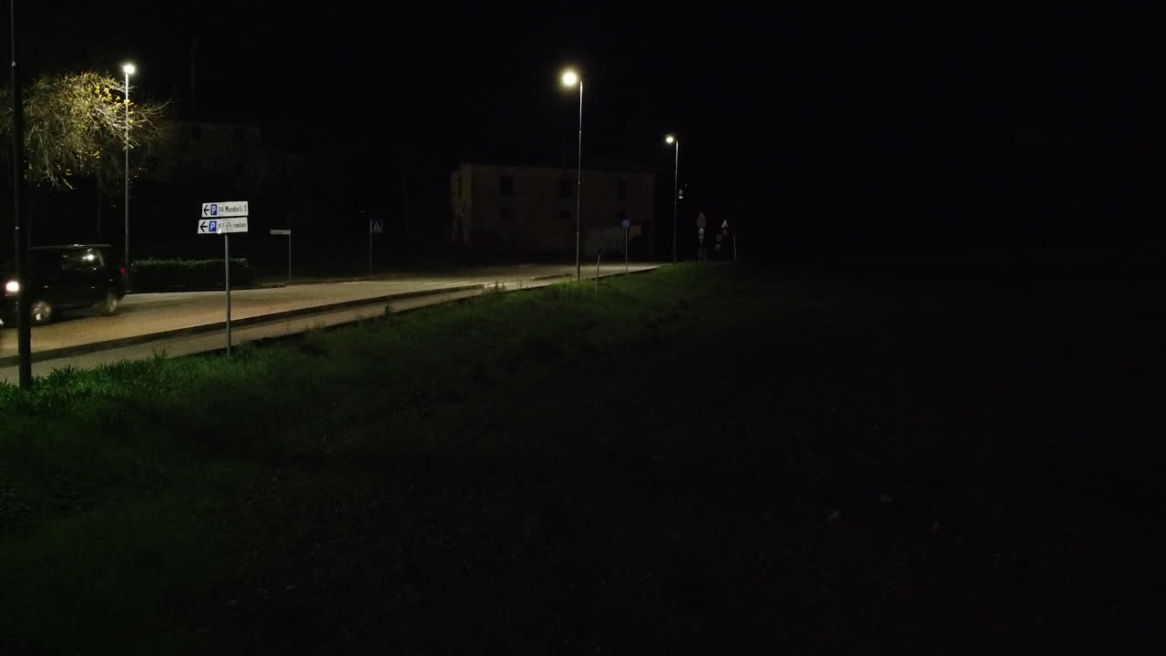 toma fija del tráfico de vehículos en una carretera de campo por la noche con luces de la calle