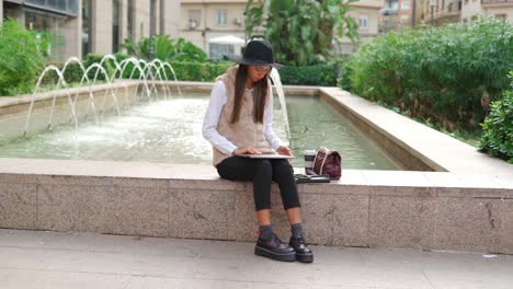 hispanic woman browsing laptop on street