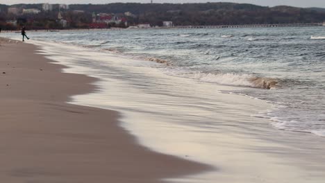 a person going near the sea shore on an boring, autumn day with a cold and chilly weather