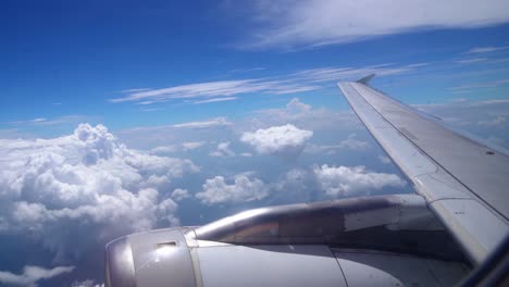 shot of beautiful fluffy clouds and wing of airplane visible from window with the view blue sky in the background