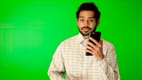 guy-using-mobile---tablet-with-green-screen-and-green-background-indian-guy-with-green-screen