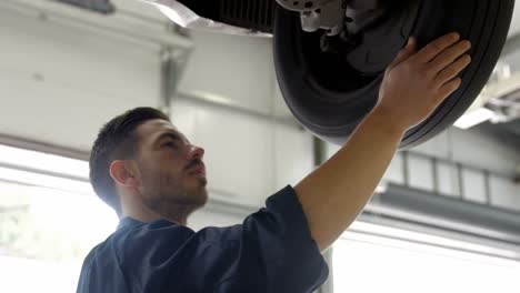 Handsome-mechanic-overhauling-a-car