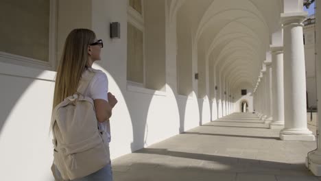 a female tourist walks in an elegant archway, admiring the stunning and beautiful architecture
