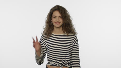 young woman showing victory sign in studio