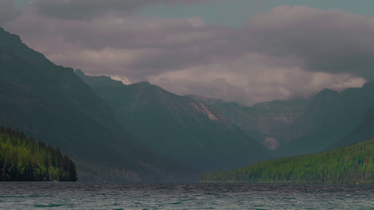 Peaceful Montana lake with mountains under cloudy sky
