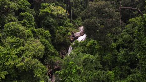 drone captura la hermosa cascada de sadet cubierta de árboles y el exuberante entorno verde de koh phangan, tailandia