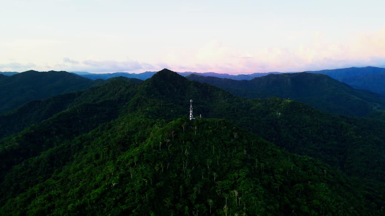 Picturesque aerial orbit of Telecommunications tower atop lush summit of Mount Cagmasuso, San Andres during dusk - Catanduanes, Bicol, Philippines