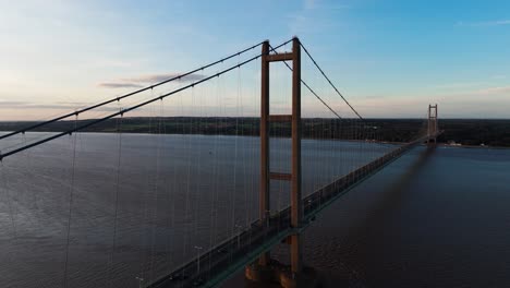 Gelassenheit-Trifft-Auf-Bewegung:-Die-Humber-Bridge-Sonnt-Sich-Im-Schein-Des-Sonnenuntergangs,-Während-Eine-Luftdrohne-Autos-Im-Harmonischen-Transit-Einfängt