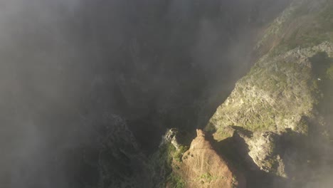 aerial shot of pico das torres in madeira looking down on the steep and dramatic peaks and deep valleys during warm sunrise