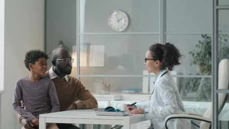 Female-Pediatrician-Talking-and-High-Fiving-African-American-Boy-on-Consultation-in-Clinic