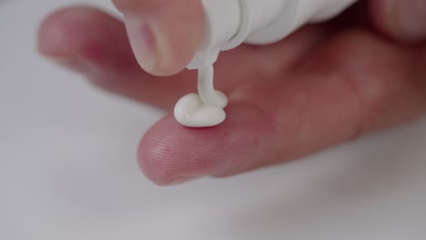 la mano de la mujer aplica crema facial cosmética