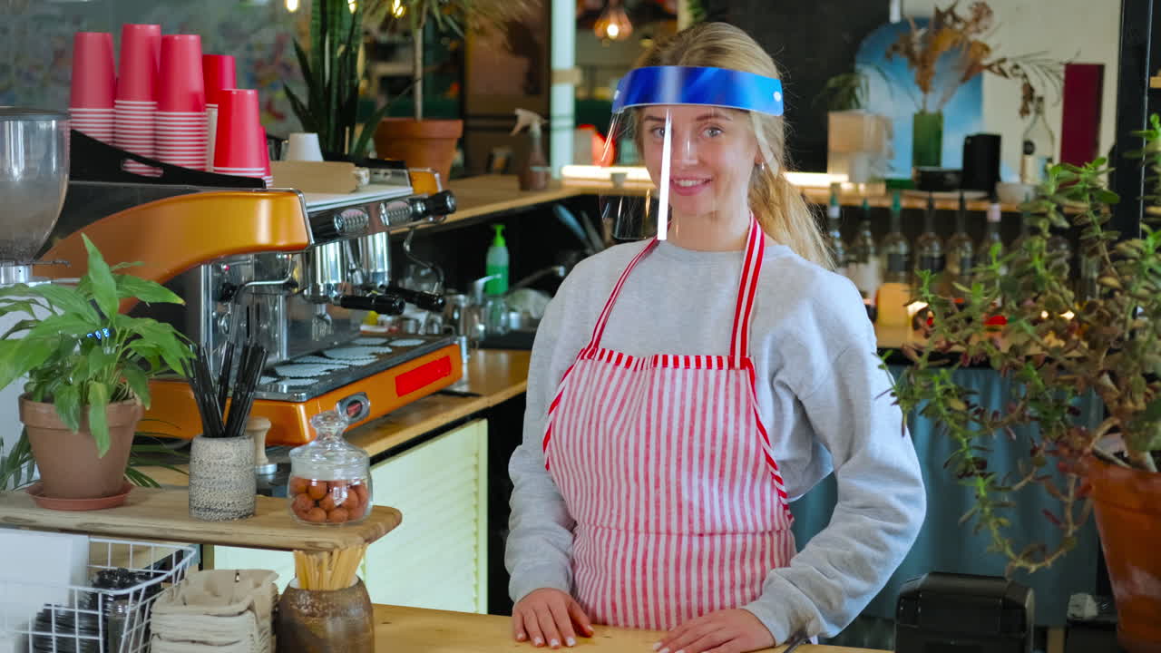 커피에서 얼굴 방패를 쓰고 있는 바리스타